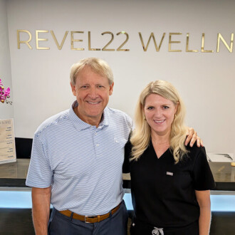 Lindsay Schwab, Revel22 Wellness Clinic Manager, and her father, Brad Ewerth, pose for a photo in the reception area.