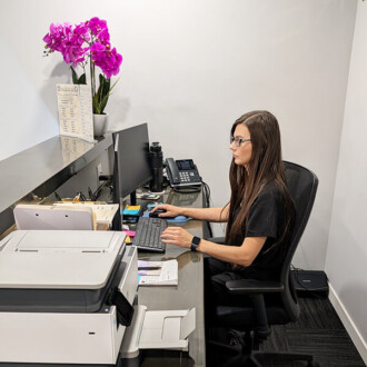 Heaven Harlander, Patient Coordinator at Revel22 Wellness, works at the front reception desk.